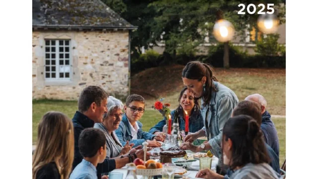 Couverture du dossier de presse 2025 de Mayenne Tourisme. On y voit une photo encadrée de blanc. En haut on peut lire Destination Mayenne. La photo représente un groupe de gens de tous âges attablés à l'extérieur pour ce qui pourrait être un repas de famille.
